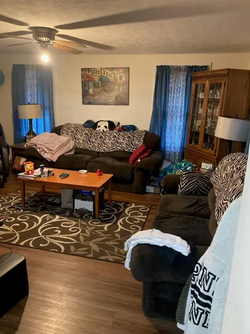 a living room with furniture a rug and a table