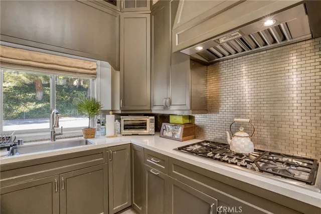 a kitchen with a stove a sink and cabinets