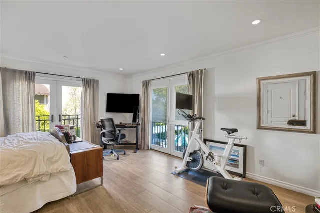 a bedroom with furniture a flat screen tv and a window