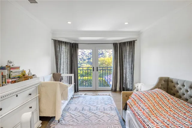 a bedroom with a bed and large windows