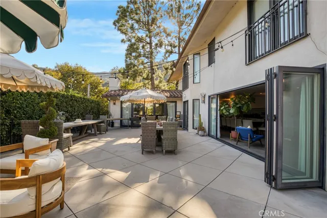 a view of a patio with couches table and chairs and potted plants