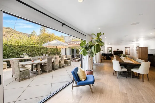 a living room with furniture a table and chairs with potted plants