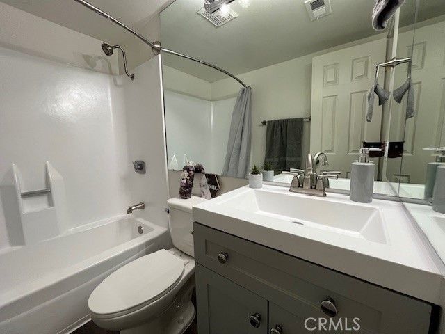 a bathroom with a sink a toilet a mirror and shower