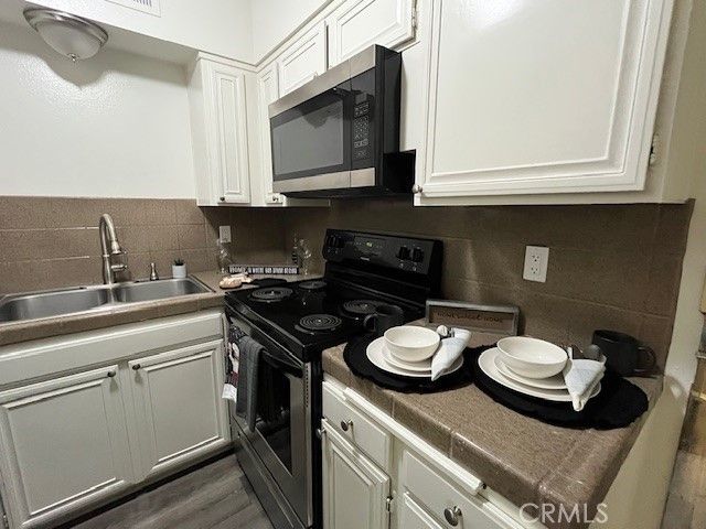 a kitchen with a sink and stove top oven