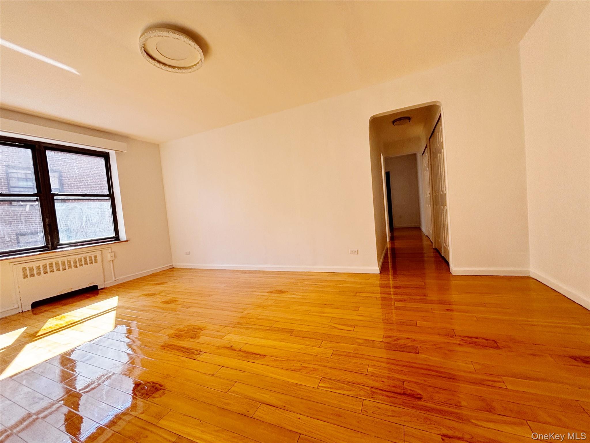 44-25 Macnish Street, Unit 4A Queens, NY 11373 - Photo 5 of 12 Spare room with radiator and light wood-style floors