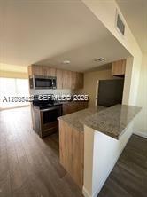 1680 Northwest 4th Avenue, Unit 8B Miami, FL 33136 - Photo 2 of 9 a kitchen with stainless steel appliances a sink a stove top oven a counter space and cabinets