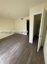 1680 Northwest 4th Avenue, Unit 8B Miami, FL 33136 - Photo 8 of 9 an empty room with wooden floor and cabinet