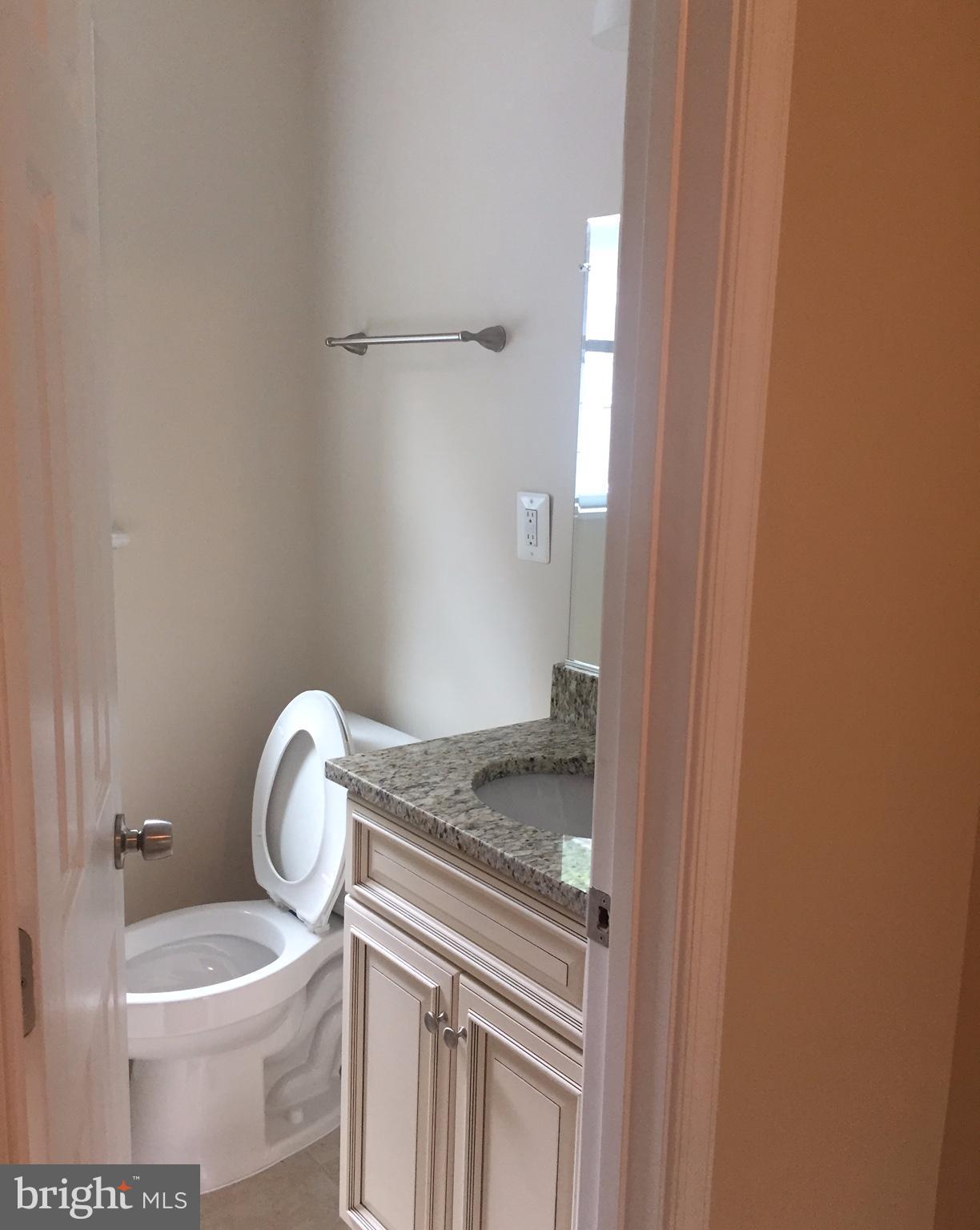 12001 Claridge Road Silver Spring, MD 20902 - Photo 5 of 5 a bathroom with a granite countertop toilet and a sink