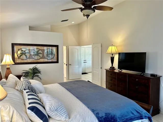 a bedroom with a bed and a lamp next to a window