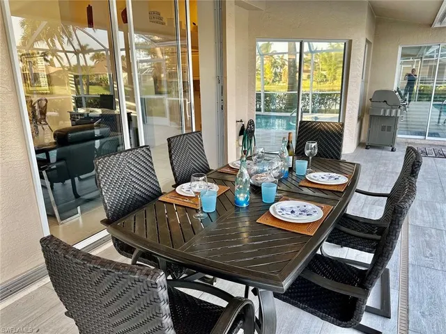 a view of a dining room with furniture one side kitchen view and a window