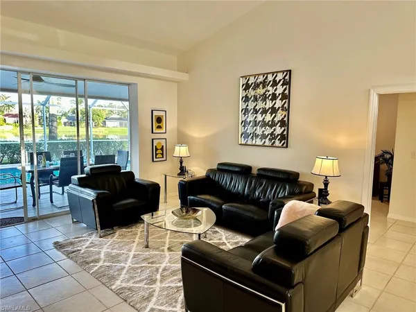 a living room with couches rug and a large window