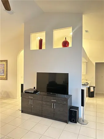 a living room with furniture a flat screen tv and kitchen view