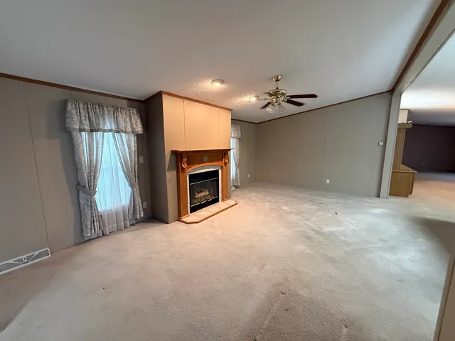 an empty room with windows cabinet and a fireplace