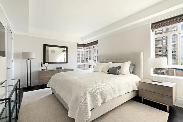 a bedroom with a bed and a dresser with mirror