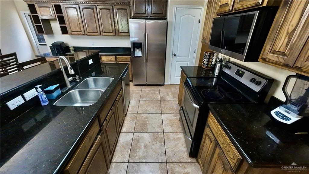 412 Rio Nueces San Juan, TX 78589 - Photo 11 of 19 a kitchen with stainless steel appliances granite countertop a sink stove and refrigerator