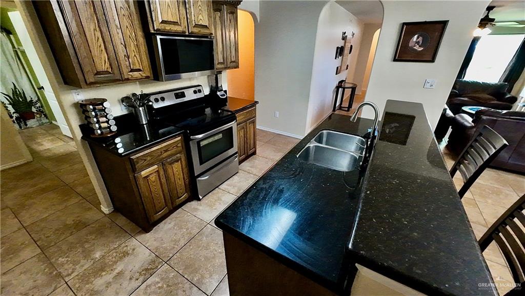 412 Rio Nueces San Juan, TX 78589 - Photo 10 of 19 a kitchen with stainless steel appliances granite countertop a stove top oven a sink and a granite counter tops