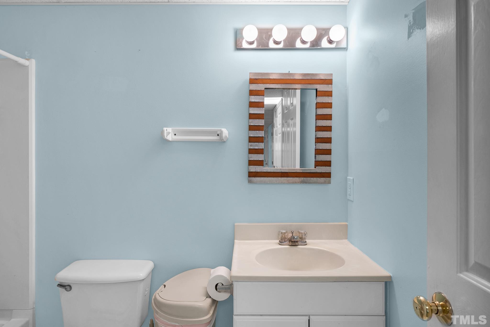 7101 Denlee Road Raleigh, NC 27603 - Photo 23 of 32 a bathroom with a toilet a sink and a window