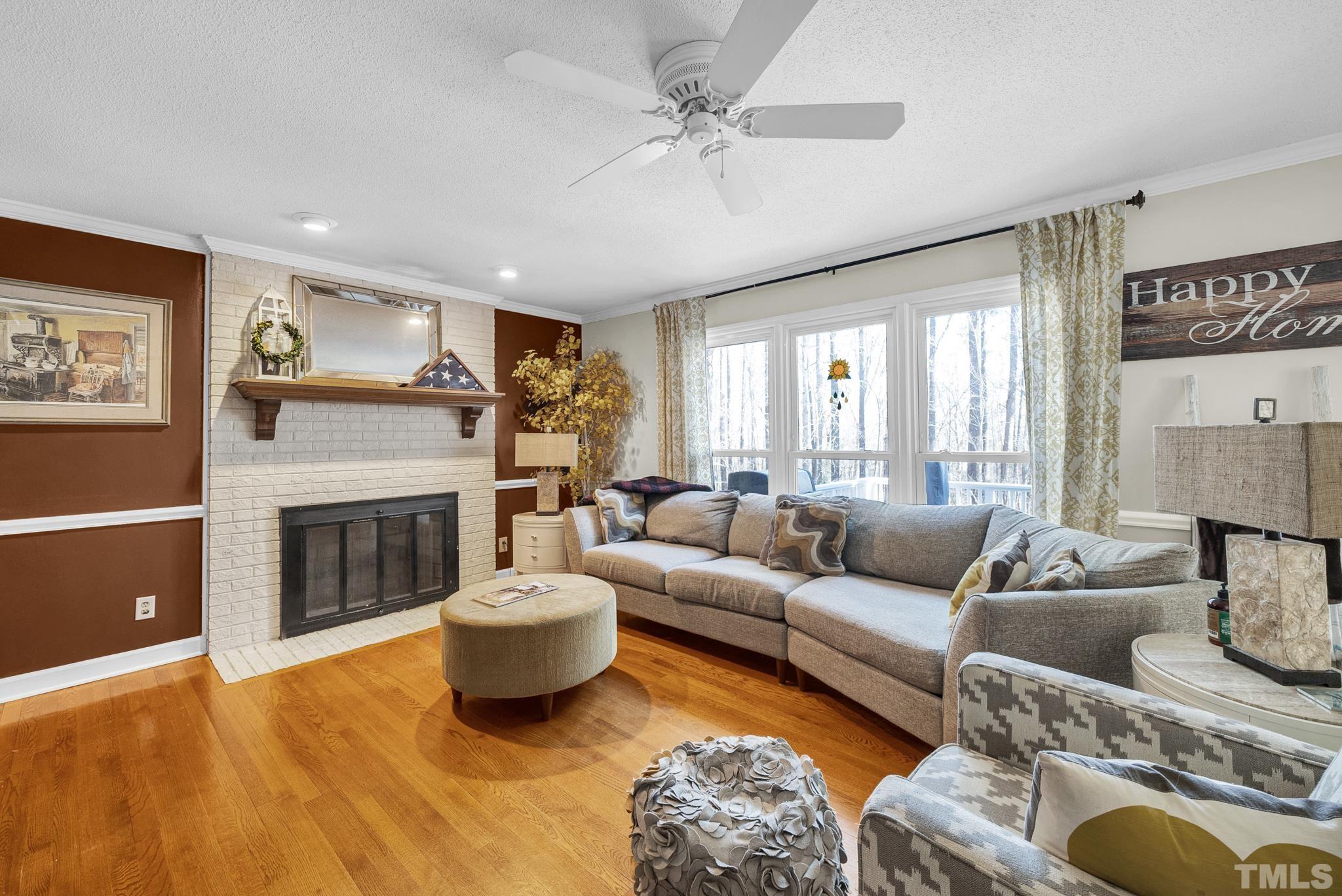 7101 Denlee Road Raleigh, NC 27603 - Photo 32 of 32 a living room with furniture a fireplace and a large window