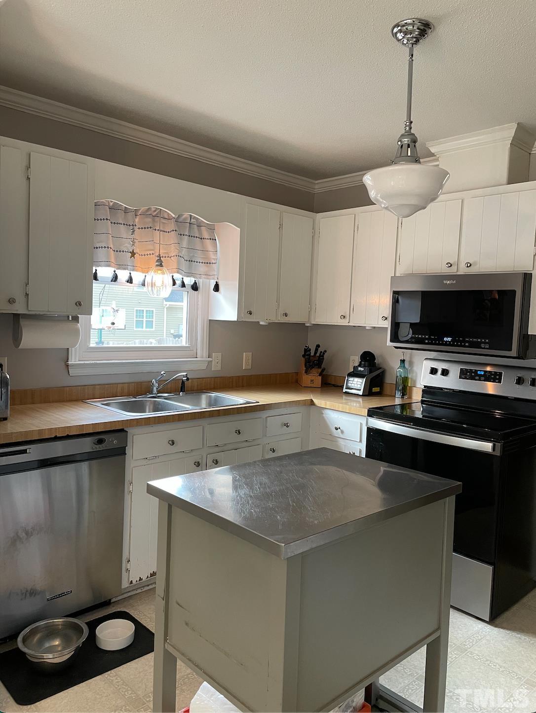 7101 Denlee Road Raleigh, NC 27603 - Photo 5 of 32 a kitchen with a stove a sink and a microwave