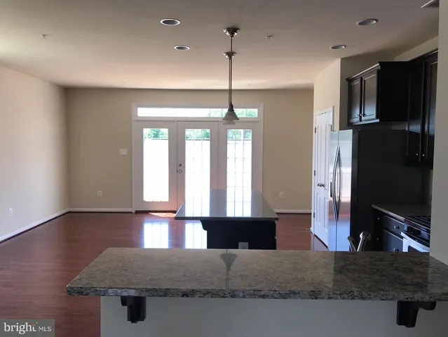a kitchen with stainless steel appliances granite countertop a sink a stove and a wooden floors