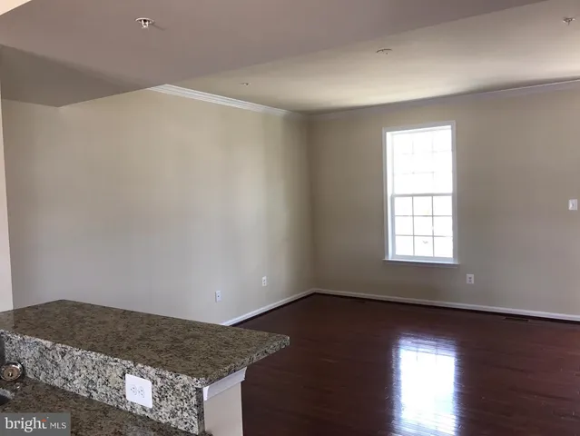 a living room with hard wood floors and a window