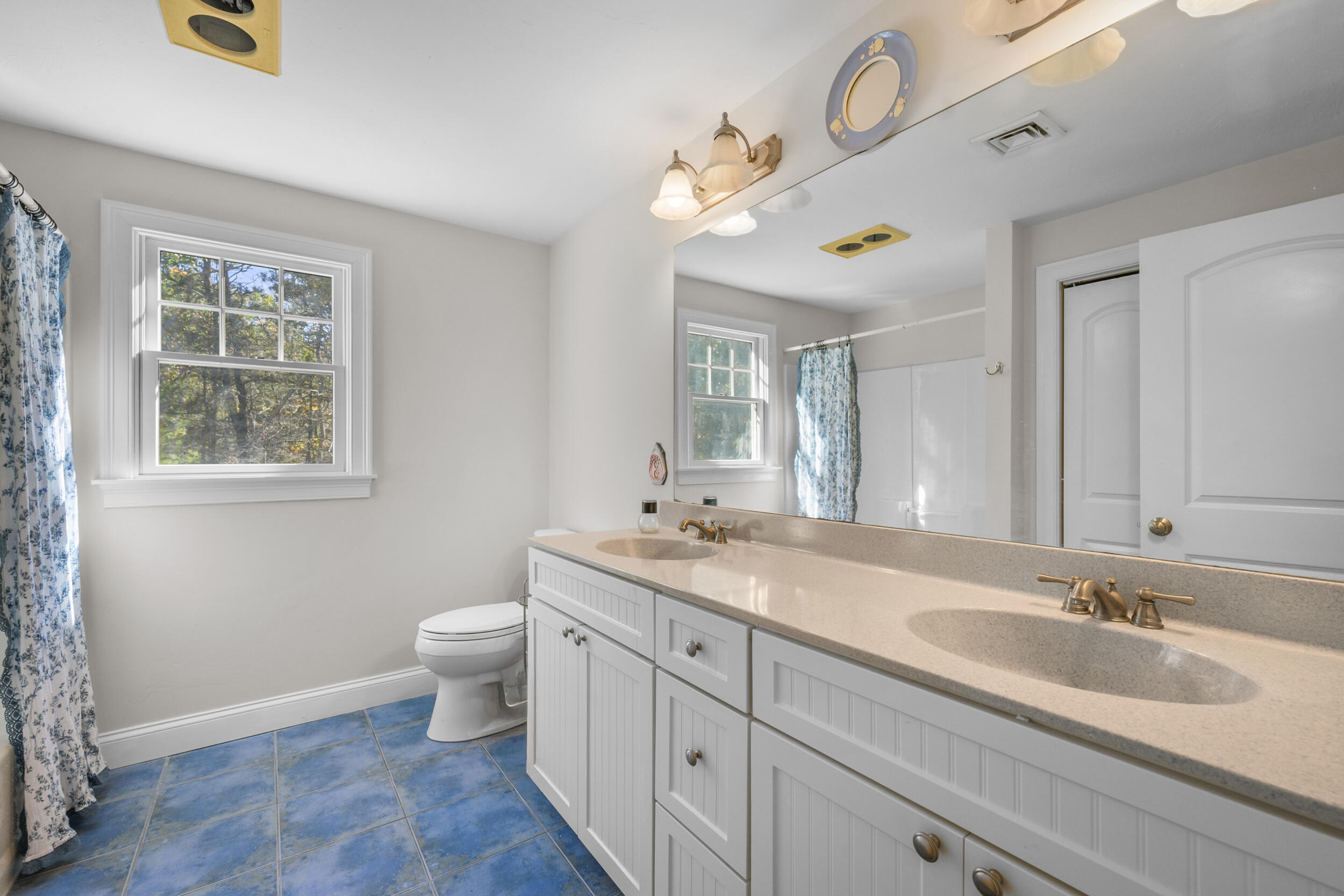 250 The Plains Road West Barnstable, MA 02668 - Photo 23 of 44 a bathroom with a toilet a sink a mirror and a window