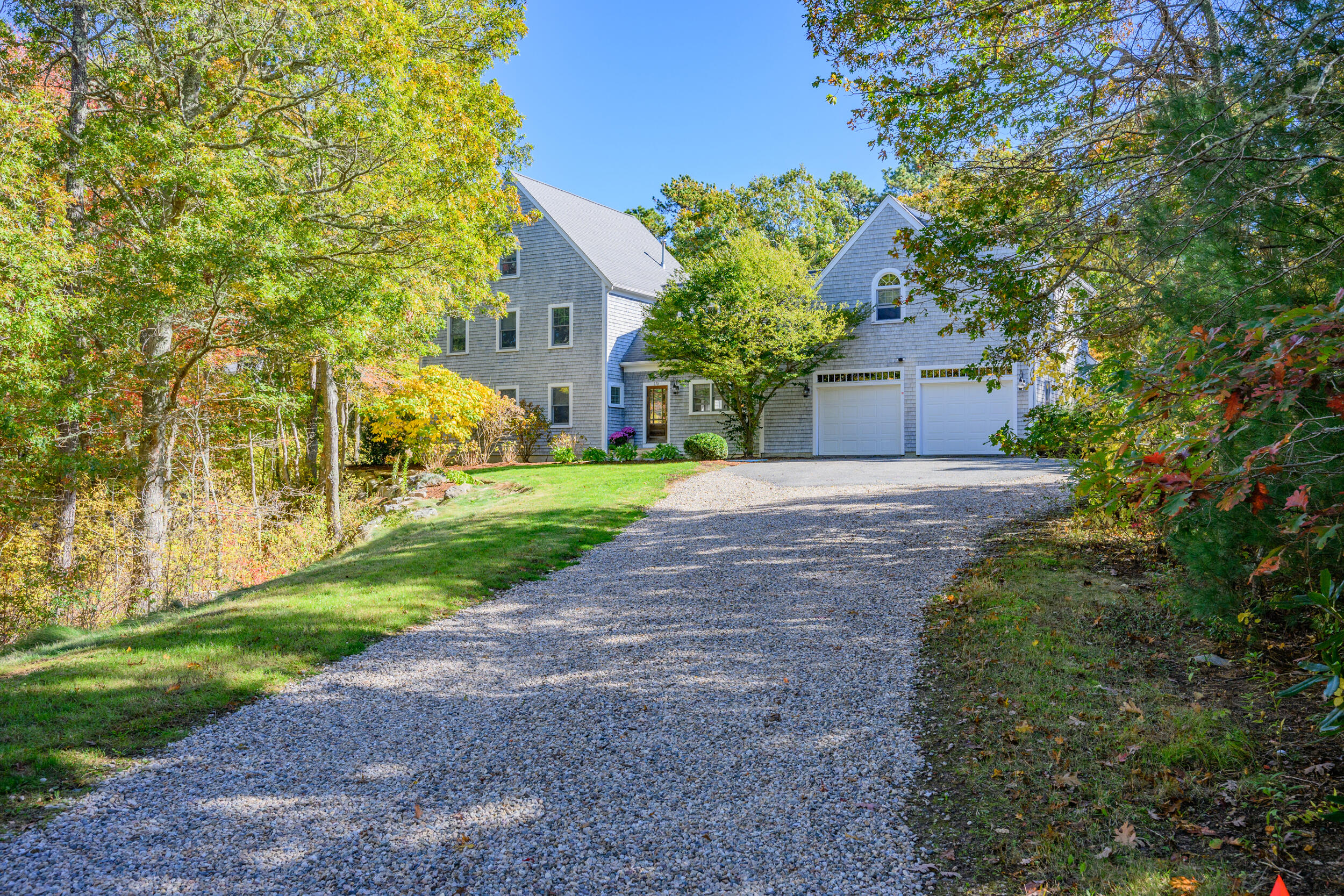 250 The Plains Road West Barnstable, MA 02668 - Photo 34 of 44 a front view of a house with a yard and trees