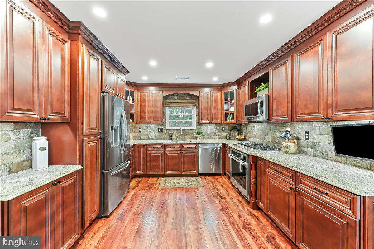 780 Tannery Drive Wayne, PA 19087 - Photo 28 of 59 a large kitchen with stainless steel appliances granite countertop wooden cabinets a sink and a stove
