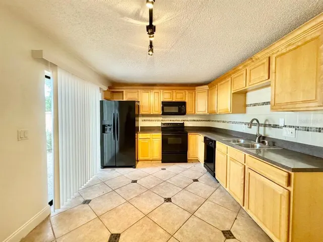 a kitchen with stainless steel appliances granite countertop a stove a sink dishwasher a refrigerator and a microwave