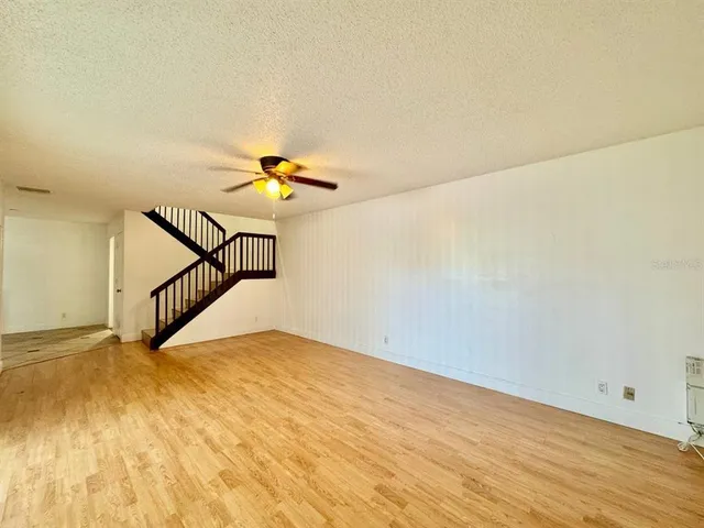 a view of a room with wooden floor and white walls