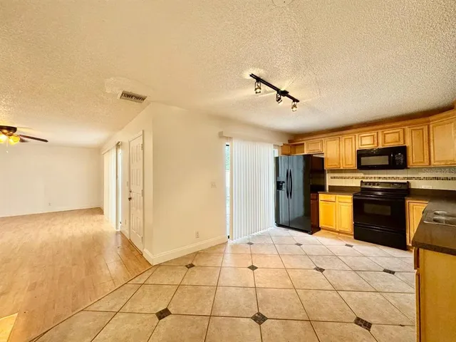 a kitchen with stainless steel appliances kitchen island granite countertop a refrigerator and a sink