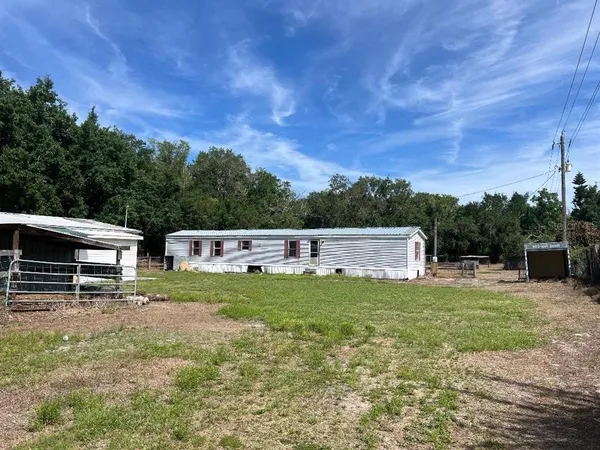 a view of a house with a yard and sitting area