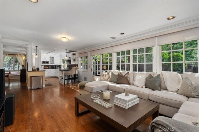 a living room with furniture flat screen tv and hard wood flooring