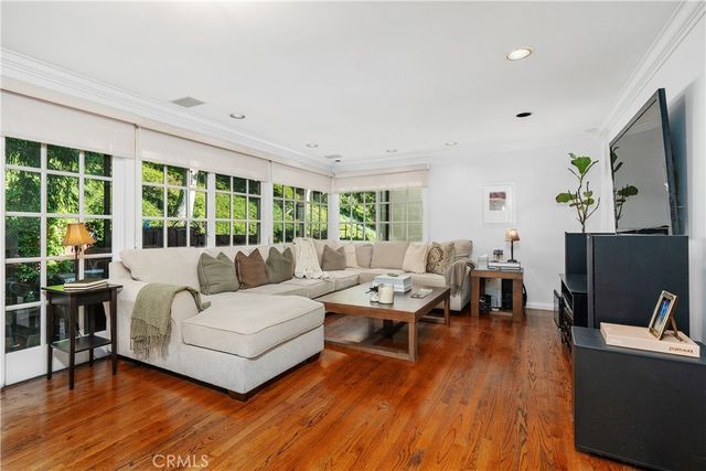 a living room with furniture and a flat screen tv with wooden floor