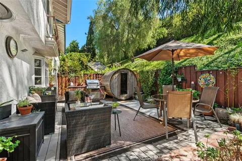 a view of a patio with table and chairs potted plants and tree
