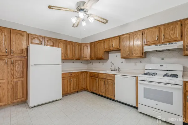 a kitchen with stainless steel appliances granite countertop a refrigerator stove a sink and dishwasher with white cabinets