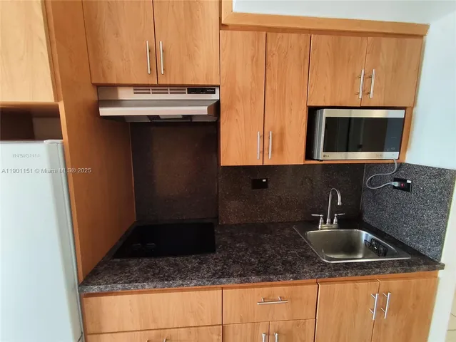 a kitchen with a sink a microwave and cabinets