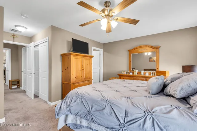 a spacious bedroom with a bed and a chandelier