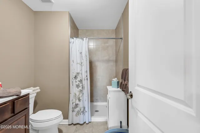 a white toilet sitting next to a shower curtain