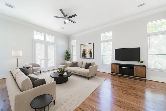 a living room with furniture a flat screen tv and a large window