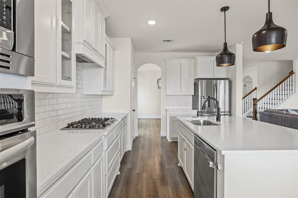 9437 Wildcat Ridge Godley, TX 76044 - Photo 11 of 37 a kitchen with granite countertop a sink a stove and refrigerator