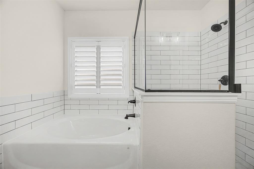 9437 Wildcat Ridge Godley, TX 76044 - Photo 16 of 37 a bathroom with bathtub next to a window