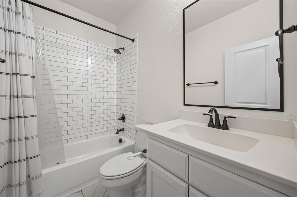 9437 Wildcat Ridge Godley, TX 76044 - Photo 18 of 37 a bathroom with a sink a toilet and shower