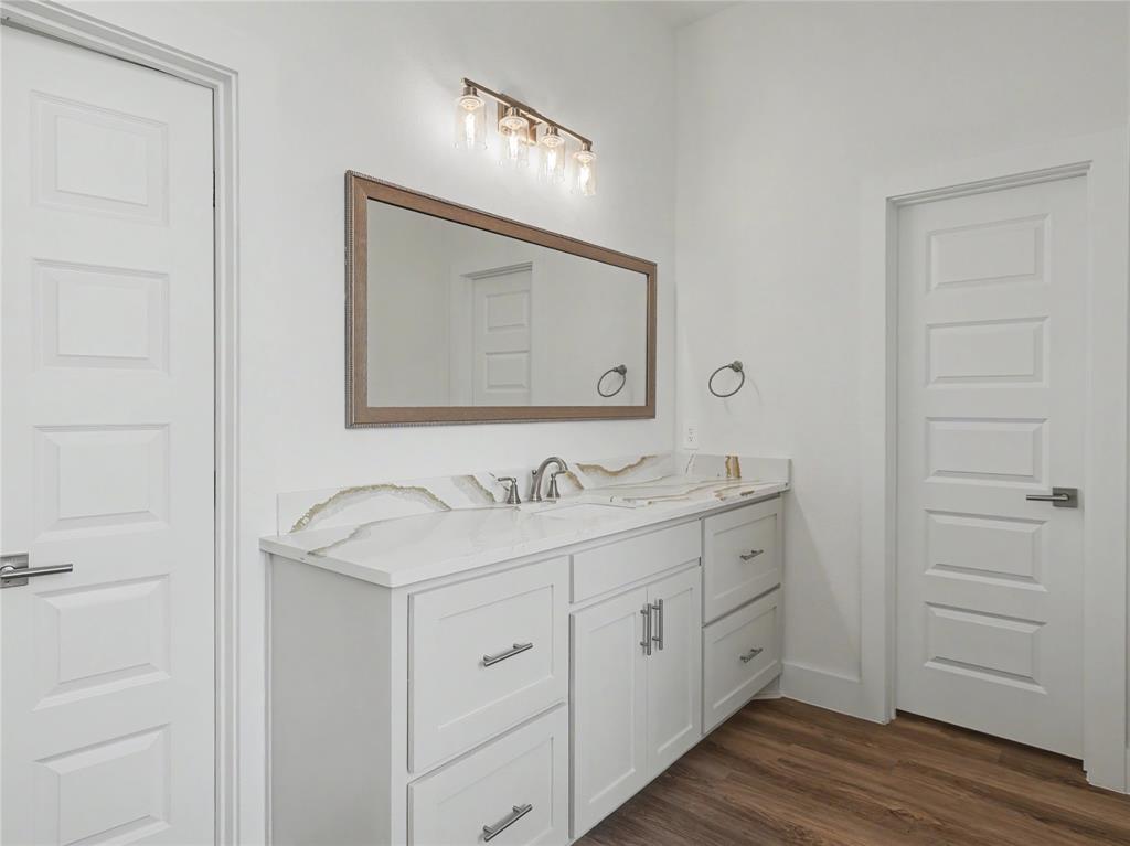 328 Slimp Bluff Azle, TX 76020 - Photo 16 of 30 Contemporary vanity featuring a dual-sink countertop with an integrated backsplash, shaker-style cabinetry, and brushed nickel hardware