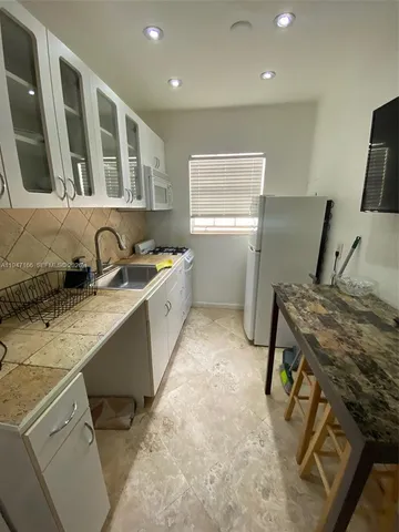 a bathroom with a toilet a sink and glass door