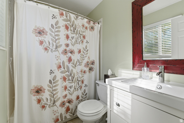 11189 Ohenry Road East Sandy, UT 84070 - Photo 17 of 44 Bathroom featuring a white vanity with integrated sink, chrome faucet, and a distressed red framed mirror