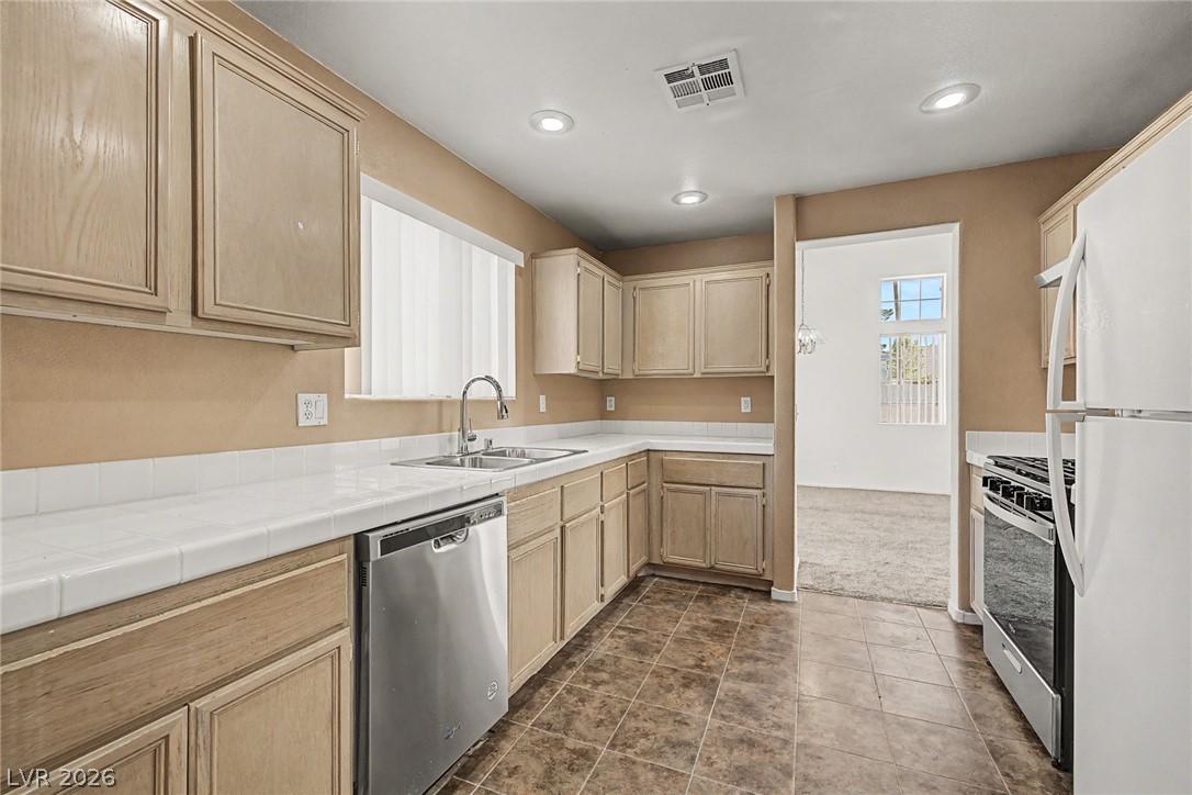 2223 Ramsgate Drive Henderson, NV 89074 - Photo 8 of 32 A well-appointed kitchen features ample cabinetry, bright counters, and modern appliances, perfect for daily living.