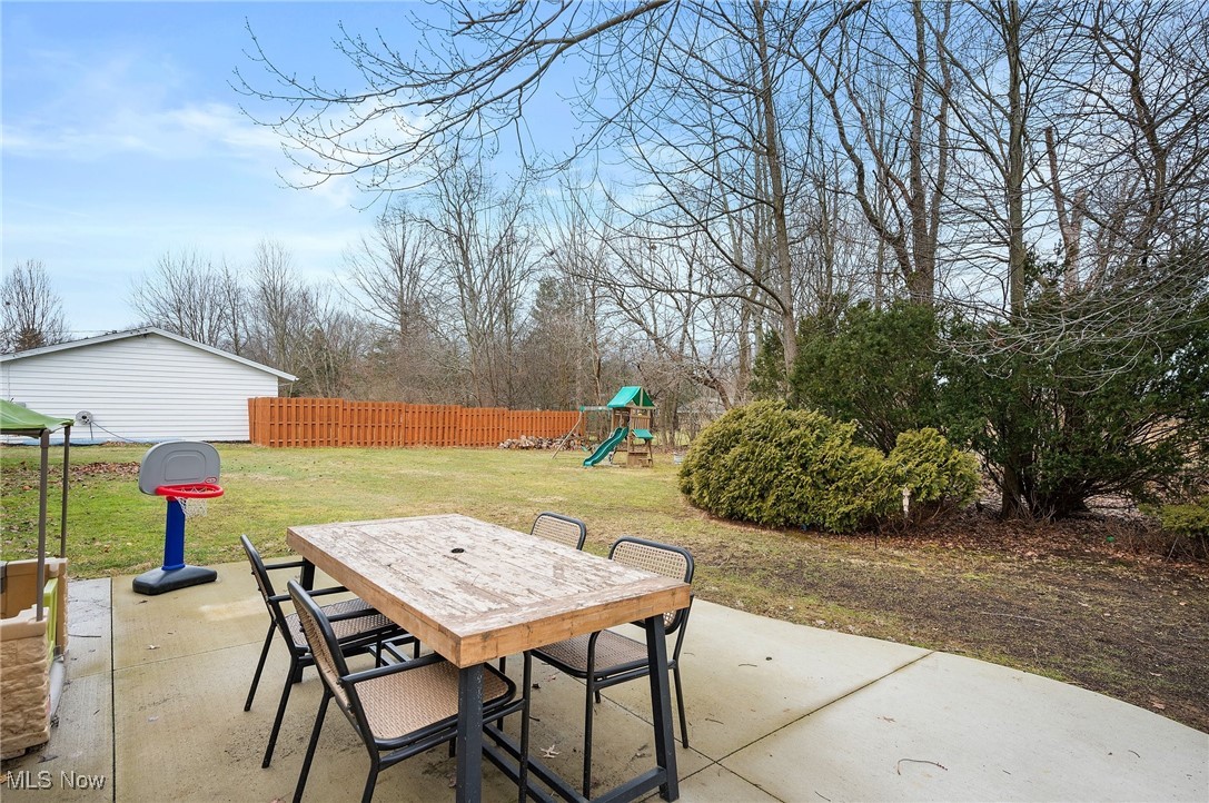 87 Kenridge Road Akron, OH 44333 - Photo 23 of 48 View of patio / terrace featuring fence, a playground, and outdoor dining space