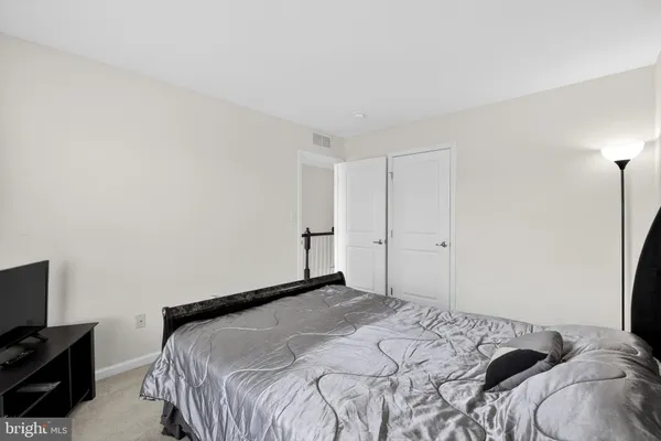 a bedroom with a flat screen tv and a lamp