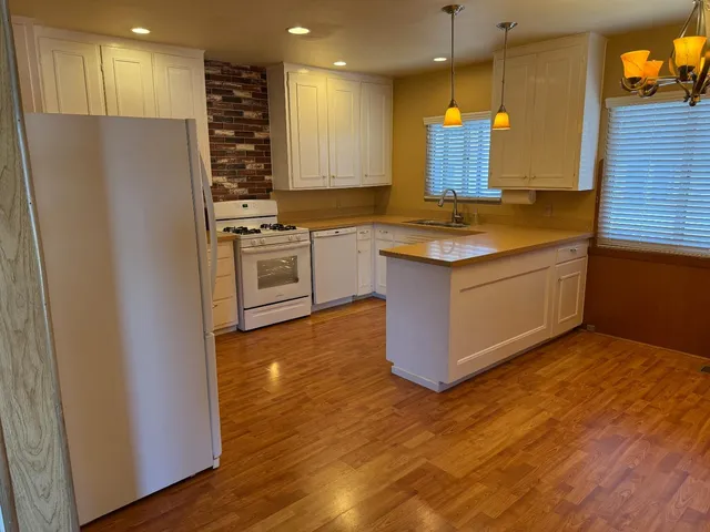 a kitchen with stainless steel appliances granite countertop a stove a sink and a refrigerator